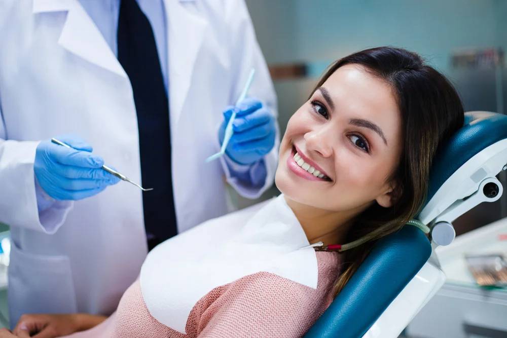 A patient smiling while learning about dental implant aftercare.